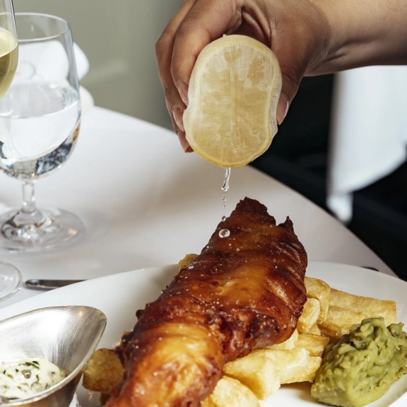 Crispy fish and chips with lemon at Bentley's, a renowned fish restaurant in Mayfair.