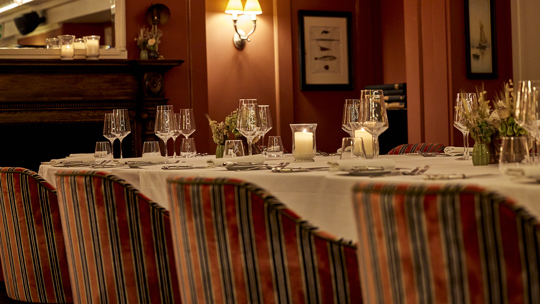 Cozy bar seating with warm lighting at Bentley’s Oyster Bar, a stylish seafood restaurant in Mayfair.
