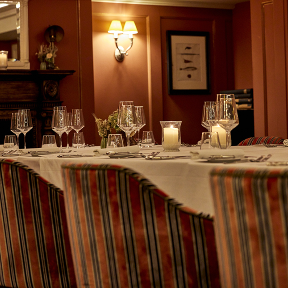 Cozy bar seating with warm lighting at Bentley’s Oyster Bar, a stylish seafood restaurant in Mayfair.