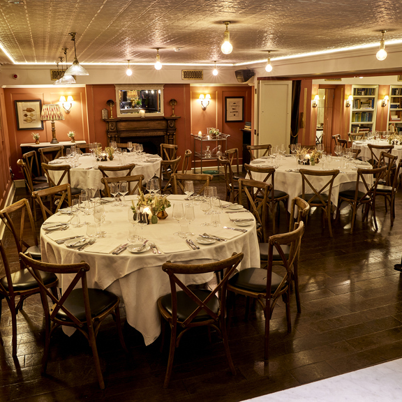 Guests enjoying drinks on a sunny patio at Bentley’s Oyster Bar, a seafood restaurant in Mayfair.