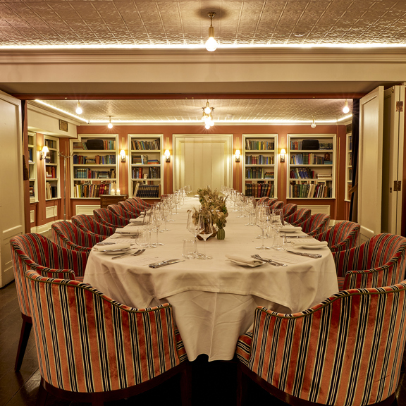 Elegant dining setup with crisp white tablecloths and ambient lighting at Bentley’s Oyster Bar, a renowned restaurant in Mayfair London.
