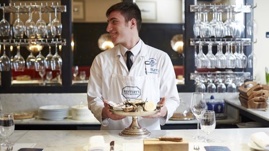 Oyster shucker at Bentley's Oyster Bar & Grill seafood restaurant in Mayfair, London