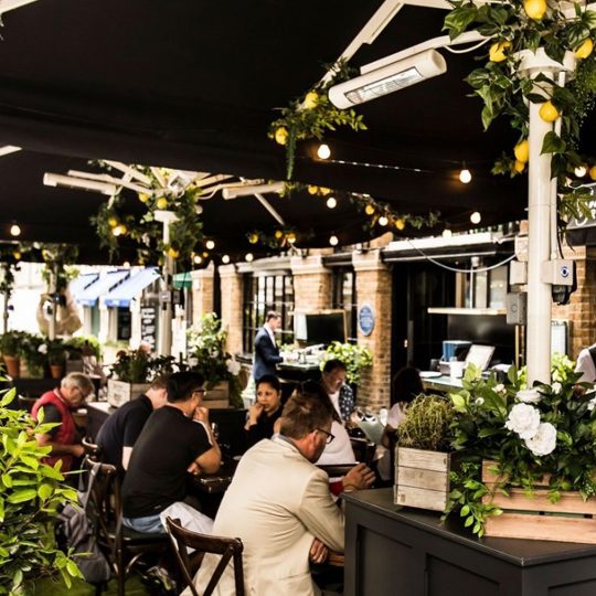 People dining in the terrace at Bentley's Oyster Bar & Grill seafood restaurant in Mayfair, London