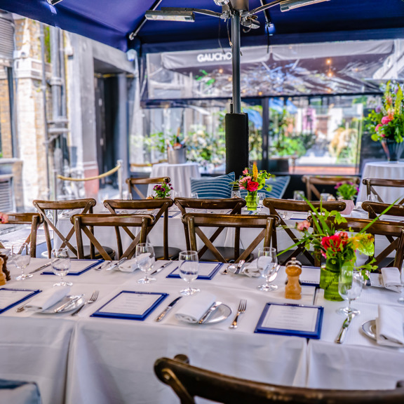 Elegant outdoor table setting with flowers and menus at Bentley's Oyster Bar, a seafood restaurant in Mayfair.
