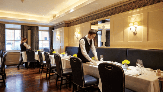 Tables being laid at Bentley's Oyster Bar & Grill seafood restaurant in Mayfair, London
