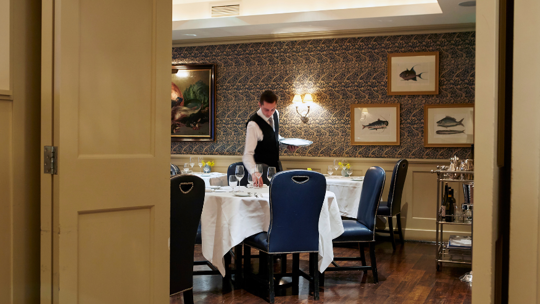 Waiter laying the table at Bentley's Oyster Bar & Grill seafood restaurant in Mayfair, London