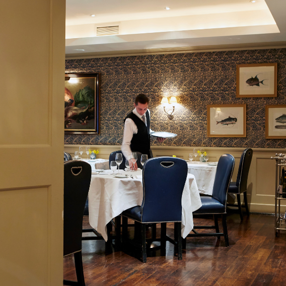Waiter laying the table at Bentley's Oyster Bar & Grill seafood restaurant in Mayfair, London
